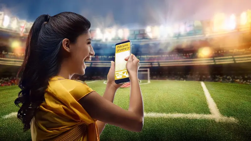 A person using a phone at a sports ground, illustrating browser access on mobile.